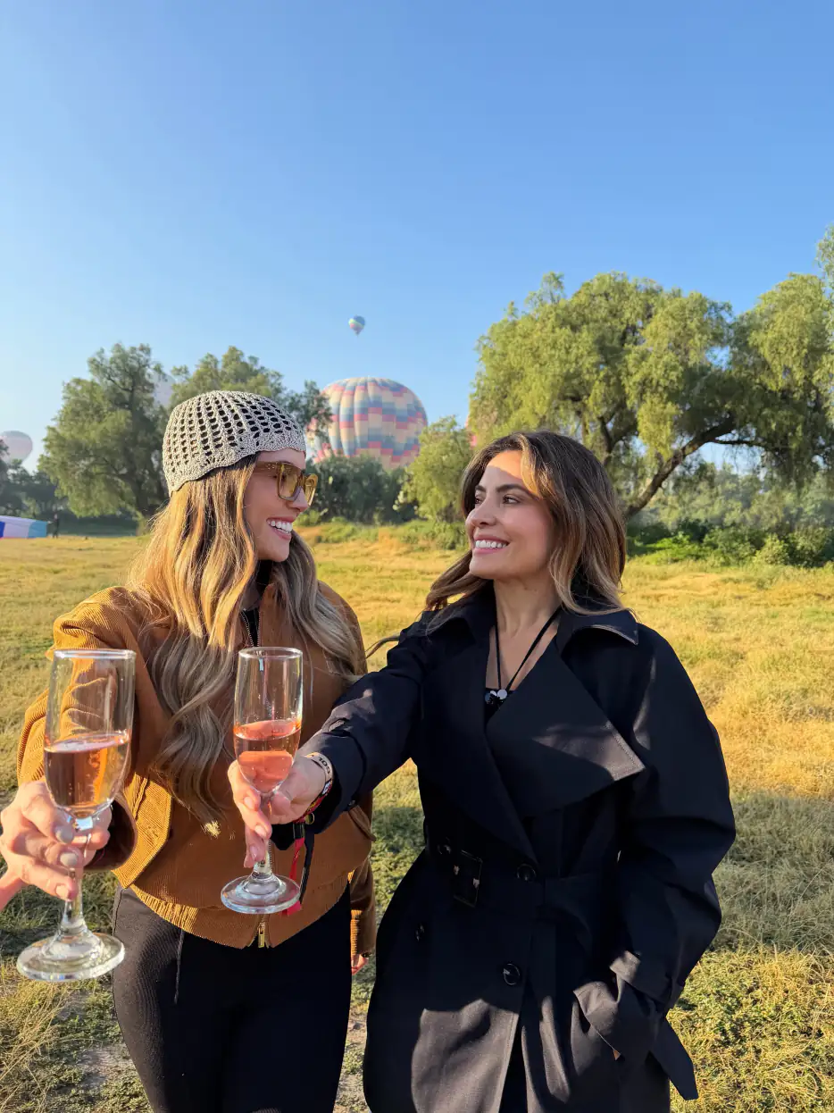 Amigas brindando con champán después de su vuelo en globo aerostático en Teotihuacán